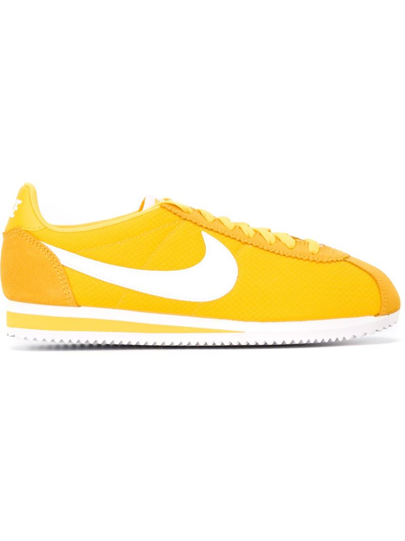 white and yellow nike cortez