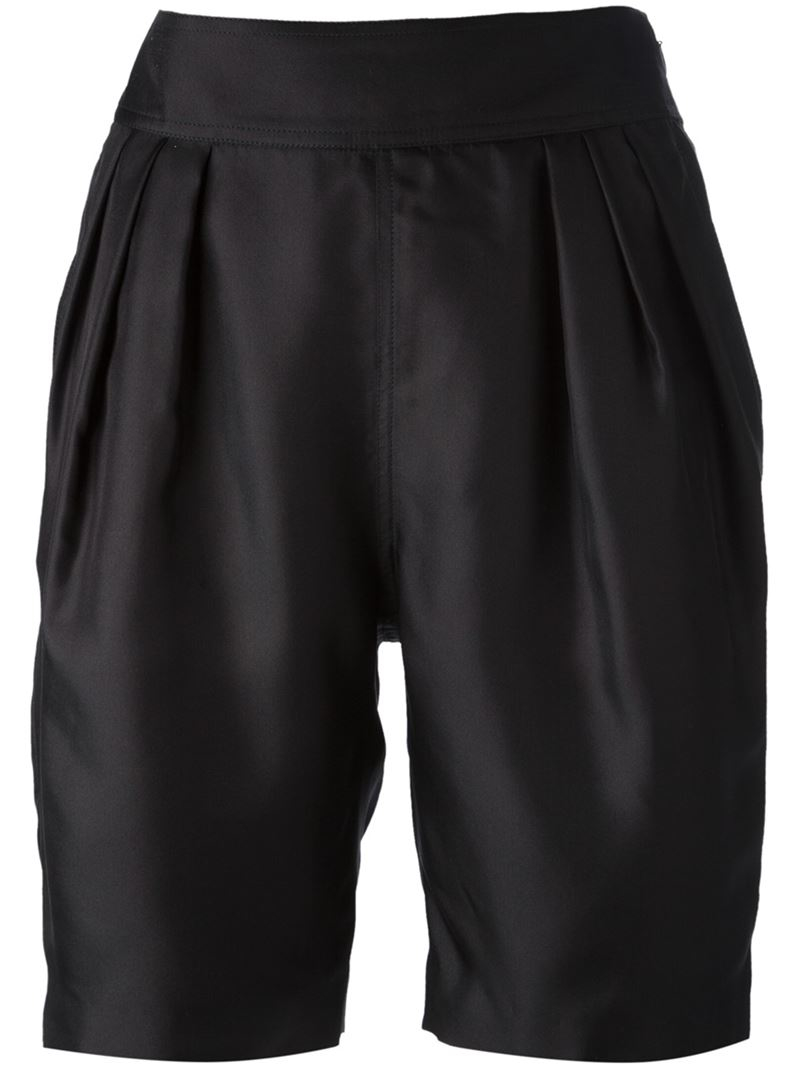 Black pleated shorts Front and back pleats add flow to black lace construction that flares like a skirt with the coverage of shorts.